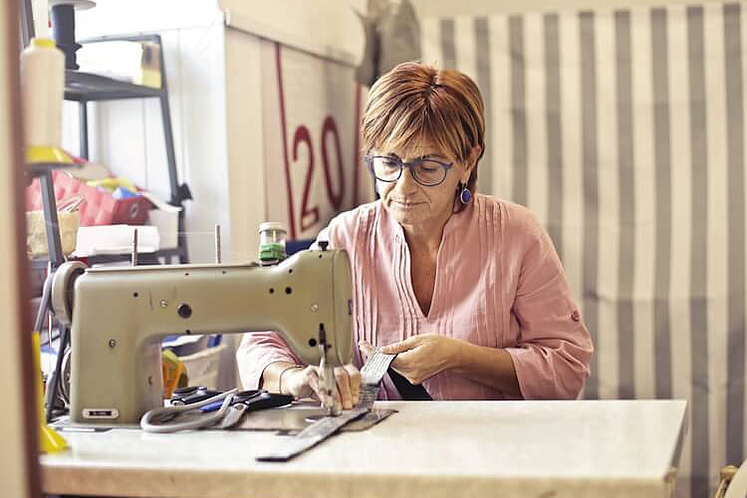 Eine Frau arbeitet in einer Änderungsschneiderei.